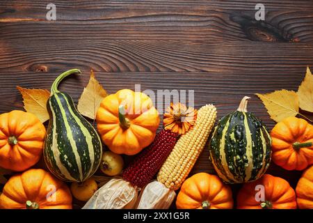 Thanksgiving- und Herbstdekorationskonzept aus Herbstblättern und Kürbis auf hölzernem Hintergrund. Flach, Draufsicht mit Kopierraum. Stockfoto