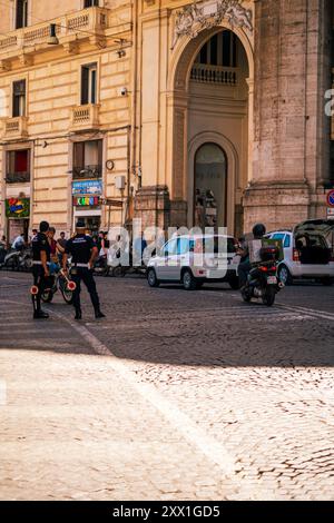 Neapel, Italien - 24. Juni 2024: Stadtszene mit Polizeibeamten auf Motorrädern in den belebten Straßen einer italienischen Stadt. Der historische Architekt Stockfoto