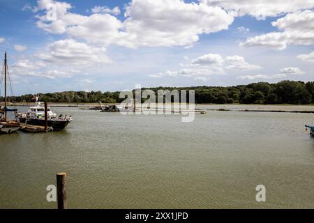 Melton, Suffolk, 21. August 2024, die Leute waren in der Deben Cafe Bar auf der HMS Vale in der Sonne, Melton, und genossen die wunderschöne Aussicht über den Fluss Deben in Suffolk. Während der Sommerferien liegen viele Boote entlang des Flusses vor. Die Temperatur beträgt zu dieser Jahreszeit angenehme 21 °C. Quelle: Keith Larby/Alamy Live News Stockfoto