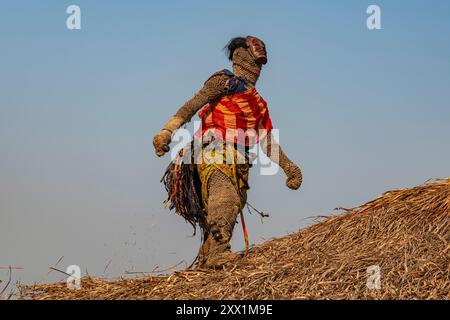 Traditioneller maskierter Mann, der auf einem Dach einer Hütte tanzt, Tshikapa, Kasai, Demokratische Republik Kongo, Afrika Stockfoto