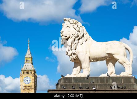 The South Bank Lion on on Westminster Bridge, gegossen 1837, mit Big Ben (The Elizabeth Tower) aus dem Palace of Westminster, London, England Stockfoto