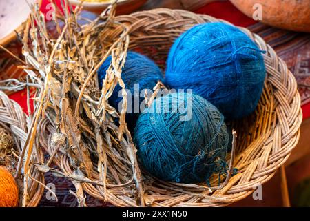 Blaue Wollkugeln und getrocknete Pflanzen als Naturfarbstoff, Chinchero, Heiliges Tal, Provinz Urubamba, Region Cusco (Cuzco), Peru, Südamerika Stockfoto