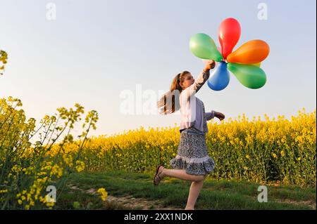 Kleines Mädchen, das mit Ballons auf den Feldern spielt, Departement Eure-et-Loir, Region Centre, Frankreich, Europa Stockfoto