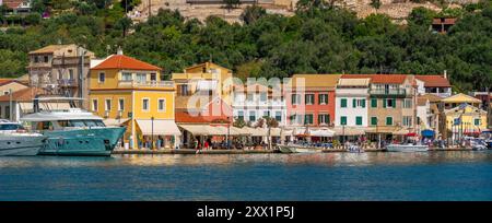 Blick auf Boote und farbenfrohe Gebäude im Hafen von Gaios, Paxos, Ionisches Meer, griechische Inseln, Griechenland, Europa Stockfoto