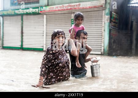 Feni, Chittagong, Bangladesch. August 2024. Eine Familie trägt ihr Kind auf den Schultern, während sie durch das Wasser waten, bis zu ihren Taille und Knien in Sicherheit in Munsirhat im Bezirk Feni der Chittagong Division, Bangladesch. (Kreditbild: © Muhammad Amdad Hossain/ZUMA Press Wire) NUR REDAKTIONELLE VERWENDUNG! Nicht für kommerzielle ZWECKE! Stockfoto