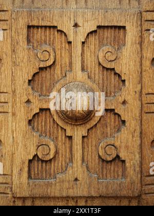 Der detaillierte Blick auf eine hoch verzierte Holztür zeigt komplizierte Schnitzereien und traditionelle Handwerkskunst, die historische Holzarbeiten widerspiegeln. Stockfoto