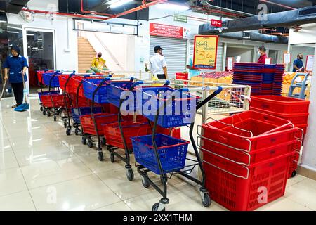 Eine Reihe von Kunststoffkörben mit Rollwagen auf Rädern für den Komfort der Kunden in einem Supermarkt. Kuala Lumpur, Malaysia - 05.30.2020 Stockfoto