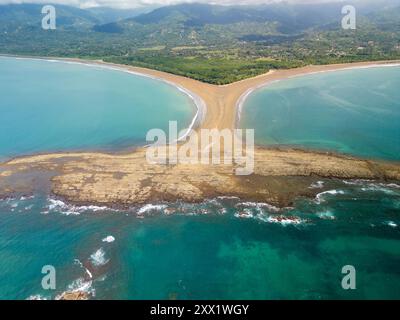 Aus der Vogelperspektive die Walschwanzformation im Marino Ballena Nationalpark in Costa Rica, mit klarem türkisfarbenem Wasser und üppigen grünen Hügeln Stockfoto