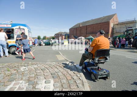 Mann auf einem Mobilitätsroller in Ilkeston, Derbyshire, Großbritannien Stockfoto