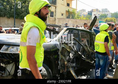 Sidon, Libanon. August 2024. Menschen versammeln sich um ein Fahrzeug, das am 21. August 2024 von Raketen einer israelischen Drohne in Sidon, Libanon, zerstört wurde. Eine israelische Drohne feuerte am Mittwochmorgen zwei Luft-Boden-Raketen auf einen zivilen SUV am Südeingang der Stadt Sidon ab und tötete einen Führer der Al-Aqsa Märtyrer-Brigaden, dem bewaffneten Flügel der Palästinensischen Nationalen Befreiungsbewegung (Fatah), sagten libanesische Militärquellen gegenüber Xinhua. Quelle: Ali Hashisho/Xinhua/Alamy Live News Stockfoto