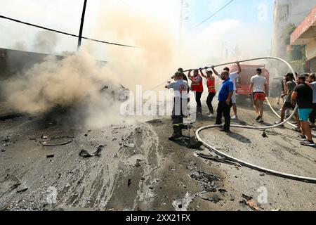 Sidon, Libanon. August 2024. Am 21. August 2024 versuchen Menschen, ein Feuer auf einem Fahrzeug zu löschen, das von Raketen einer israelischen Drohne getroffen wurde. Eine israelische Drohne feuerte am Mittwochmorgen zwei Luft-Boden-Raketen auf einen zivilen SUV am Südeingang der Stadt Sidon ab und tötete einen Führer der Al-Aqsa Märtyrer-Brigaden, dem bewaffneten Flügel der Palästinensischen Nationalen Befreiungsbewegung (Fatah), sagten libanesische Militärquellen gegenüber Xinhua. Quelle: Ali Hashisho/Xinhua/Alamy Live News Stockfoto