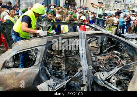 Sidon, Libanon. August 2024. Die Leute überprüfen ein Fahrzeug, das am 21. August 2024 von Raketen einer israelischen Drohne in Sidon, Libanon, zerstört wurde. Eine israelische Drohne feuerte am Mittwochmorgen zwei Luft-Boden-Raketen auf einen zivilen SUV am Südeingang der Stadt Sidon ab und tötete einen Führer der Al-Aqsa Märtyrer-Brigaden, dem bewaffneten Flügel der Palästinensischen Nationalen Befreiungsbewegung (Fatah), sagten libanesische Militärquellen gegenüber Xinhua. Quelle: Ali Hashisho/Xinhua/Alamy Live News Stockfoto