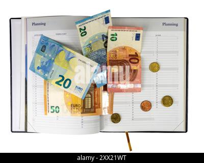 Einige Euro-Banknoten und -Münzen liegen auf offenem Kalender mit sichtbaren Monaten und Wochentagen. Stockfoto