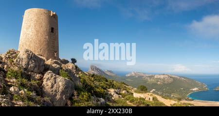 Frau, die sich gegen den Wachturm Talaia d'Albercutx in der Nähe von Puerto de Pollensa lehnt und ein Foto macht, Mallorca, Balearen, Spanien Stockfoto