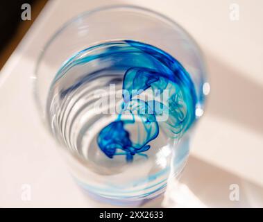 Abstrakte Nahaufnahme von Methylenblau in einem Glas Wasser Stockfoto