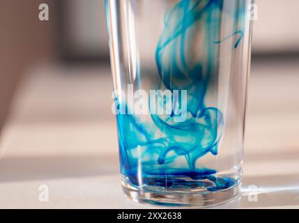 Abstrakte Nahaufnahme von Methylenblau in einem Glas Wasser Stockfoto