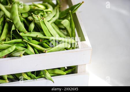 Nahaufnahme von frischen Bio-Bohnen in einer Holzkiste auf einem Tisch Stockfoto