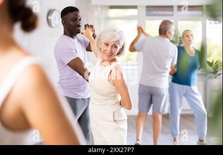 Gruppe multiethnischer Erwachsener, die Gesellschaftstanz tanzt Stockfoto
