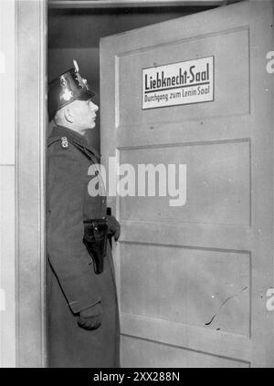 Ein Mitglied der Schutzpolizei steht bei der Schließung des Karl-Liebknecht-Hauses (KPD-Hauptquartier) in Berlin an der Tür des Liebknecht-Saals. Nachdem Hitler die Macht übergeben wurde, bewegte er sich schnell und effektiv, um sie zu behalten. Nach dem Abbrennen des Reichstags wurden die Kommunisten beschuldigt (wer tatsächlich das Feuer gelegt hat, steht noch immer im Zweifel). Nach einer rasenden anti-komunistischen Kampagne wurden sie für illegal erklärt, Mitglieder inhaftiert, ihre Büros entlassen und alle Literaturen zerstört. Nachdem die affektive Opposition so beseitigt wurde, gewannen die nazis einen Monat später leicht die Parlamentswahlen. Stockfoto