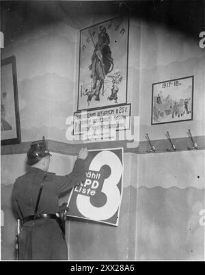 Ein Mitglied der Schutzpolizei entfernt bei der Schließung des Karl-Liebknecht-Hauses auf dem Bülowplatz in Berlin ein Wahlplakat von einer Wand. Nachdem Hitler die Macht übergeben wurde, bewegte er sich schnell und effektiv, um sie zu behalten. Nach dem Reichstagsbrand wurden die Kommunisten beschuldigt (wer tatsächlich das Feuer gelegt hat, steht noch immer im Zweifel). Nach einer rasenden anti-komunistischen Kampagne wurden sie für illegal erklärt, Mitglieder inhaftiert, ihre Büros entlassen und alle Literaturen zerstört. Nachdem die affektive Opposition so beseitigt wurde, gewannen die nazis einen Monat später leicht die Parlamentswahlen. Stockfoto