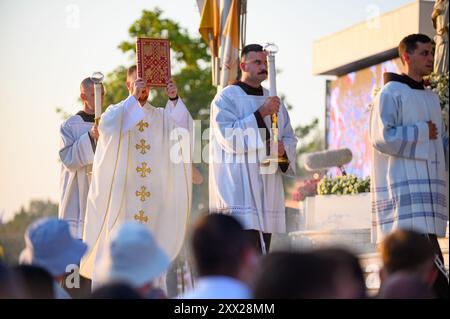 Das Evangelium wird feierlich von einem Priester in der Heiligen Messe getragen. Mladifest 2024, das jährliche Jugendfest in Medjugorje. Stockfoto