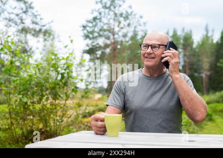 Senior Finn Mann mit Mobiltelefon im Freien in einem skandinavischen Waldsommer in Finnland Konzept Stockfoto