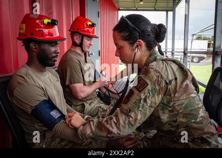 Jacksonville, Florida, USA. August 2024. Air Force Airmen, die der 125th Medical Group, Abteilung 1, Florida Air National Guard zugeteilt wurden, überprüfen die Vitalwerte der Mitglieder im Rahmen einer Übung im August. 13, 2024, Fort Buchanan, Puerto Rico. Die Übung besteht aus mehreren Schulungsveranstaltungen, die die Fähigkeiten im Bereich der Luftlast verbessern, Verfahren vor und nach dem Einsatz verfeinern, die Einsatzbereitschaft in einer unbekannten Umgebung erweitern und umfassende Anforderungen des medizinischen Bereitschaftsplans erfüllen, einschließlich Intensivmedizin, Suche und Extraktion sowie Air Force S Stockfoto