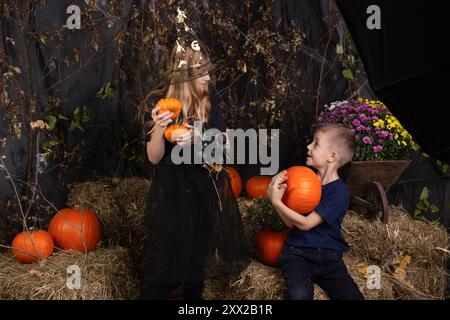 Glückliche Bruder und Schwester an Halloween. Lustige Kinder in Karnevalskostümen drinnen. Kinder, die sich auf Halloween vorbereiten Stockfoto