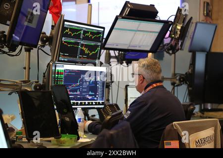 New York, USA. August 2024. Ein Trader arbeitet am 21. August 2024 auf dem Handelsplatz der New York Stock Exchange (NYSE) in New York, USA. Die US-Aktien stiegen am Mittwoch nach oben, nachdem die Federal Reserve ihr aktuelles Protokoll über geldpolitische Sitzungen bekanntgegeben hatte, das darauf hindeutete, dass die US-Zentralbank die Zinsen im September senken könnte. Quelle: Liu Yanan/Xinhua/Alamy Live News Stockfoto