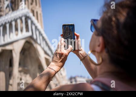 Barcelona, Spanien. August 2024. Touristen machen Fotos von der Kirche Sagrada Familia im Stadtzentrum. Mit mehr als 18 Millionen Touristen, die 2024 Barcelona besuchen werden, hat die Stadt Schwierigkeiten, ein Gleichgewicht zwischen den wirtschaftlichen Vorteilen des Tourismus während der Tourismussaison und der Notwendigkeit zu finden, die Stadt für die Einwohner lebenswert zu halten, die dem Massentourismus und der Ausbeutung der Stadt durch die Tourismusbranche feindselig gegenüberstehen. Quelle: SOPA Images Limited/Alamy Live News Stockfoto