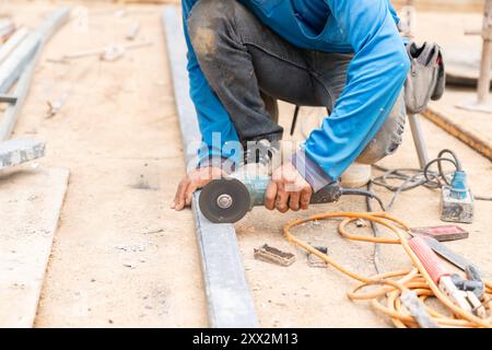 Der Arbeiter Schnitt auf der Baustelle mit der Schleifmaschine A ein Stahlrohr. Stockfoto