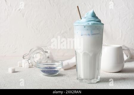 Glas blauer Dalgona Matcha Latte und Schüssel auf Grunge Tisch Stockfoto