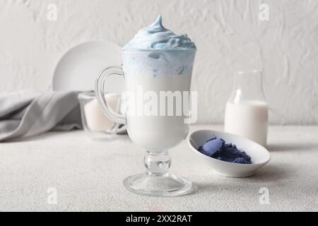Glas blauer Dalgona Matcha Latte und Schüssel auf Grunge Tisch Stockfoto