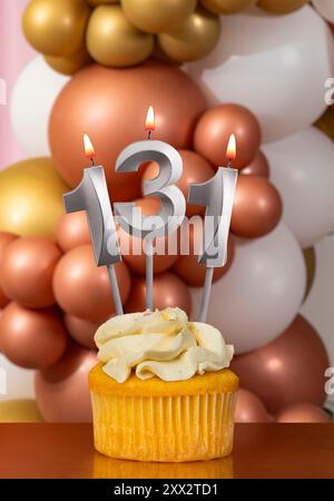 Cupcake mit Geburtstagskerze auf Ballonhintergrund - Nummer 131 Stockfoto