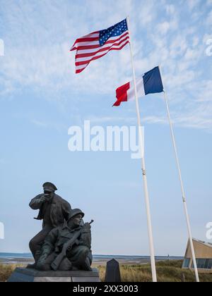 Utah Beach, Frankreich: 19. August 2024: Statue der US-Soldaten, US-amerikanische und französische Fahnen am Strand von Utah, Normandie, zum Gedenken an den D-Day, den Zweiten Weltkrieg Stockfoto