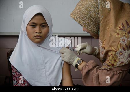 Bogor, West-Java, Indonesien. August 2024. Ein Gesundheitspersonal injiziert einer Schülerin während des Impfmonats für Schulkinder (BIAS) 2024 in einer Grundschule in Bogor, West Java, Indonesien den Impfstoff gegen das humane Papilloma Virus (HPV). Das indonesische Gesundheitsministerium zielt darauf ab, dass 90 Prozent der Grundschüler in Indonesien Impfstoffe im Programm „BIAS 2024“ erhalten. Der HPV-Impfstoff (humanes Papillomavirus) kann eine Infektion mit einigen Arten von humanen Papillomaviren verhindern. HPV-Infektionen können auch anogenitale Warzen verursachen. HPV-Impfstoff kann über 90 Prozent der durch HPV verursachten Krebserkrankungen verhindern. (C Stockfoto