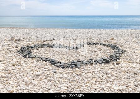 Foto von der wunderschönen Strandfront der Stadt Altea in Alicante in Spanien mit einem Liebesherz aus Steinen und Kieseln am Strand Stockfoto