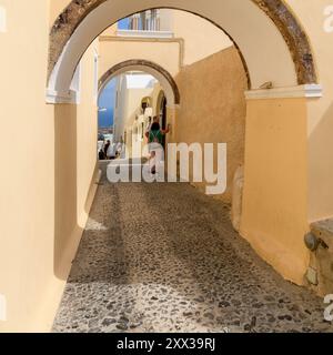 Santorin, Griechenland - 8. Oktober 2019: Ein ruhiger Spaziergang durch kopfsteingepflasterte Pfade, gesäumt von legendärer weiß getünchter Architektur. Stockfoto