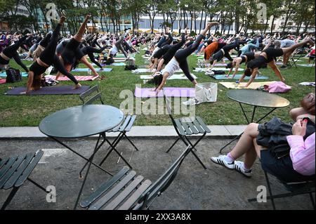 New York, USA. August 2024. Menschen nehmen an einem kostenlosen Yoga-Kurs im Bryant Park Teil, der von Colleen Saidman Lee und Rodney Lee geleitet wird, New York, NY, 21. August 2024. (Foto: Anthony Behar/SIPA USA) Credit: SIPA USA/Alamy Live News Stockfoto