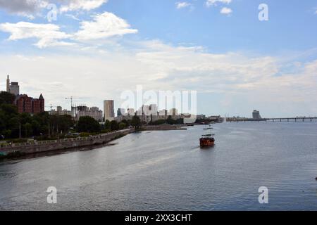 Wunderschöne und helle Landschaften des Flusses Dnieper, der Uferpromenade der Stadt Dnipro, Dnepropetrovsk. Häuser und Gebäude, gemauerte Böschungen Stockfoto