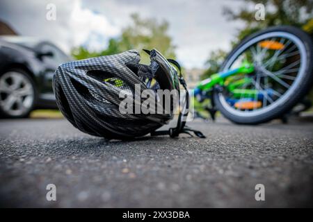 Berlin, Deutschland. August 2024. Symbolfoto zum Thema Fahrradunfälle (inszenierte Szene). Ein kaputter Fahrradhelm liegt neben einem Fahrrad auf einer Straße. Berlin, 21. August 2024. Quelle: dpa/Alamy Live News Stockfoto