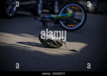 Berlin, Deutschland. August 2024. Symbolfoto zum Thema Fahrradunfälle (inszenierte Szene). Ein kaputter Fahrradhelm liegt neben einem Fahrrad auf einer Straße. Berlin, 21. August 2024. Quelle: dpa/Alamy Live News Stockfoto