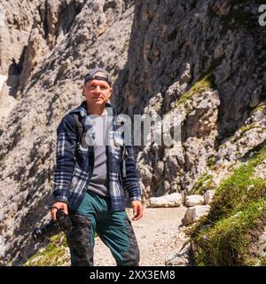 Reisefotograf mit einer professionellen Kamera in der Hand steht in einer wunderschönen Berglandschaft. Dolomitalpen. Südtirol. Italien Stockfoto
