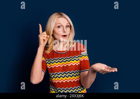 Foto von aufgeregt netten netten älteren Frau tragen stilvolle Kleidung halten Pillen isoliert auf dunkelblauem Hintergrund Stockfoto