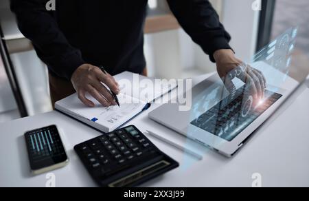 Ein Geschäftsmann plant und analysiert Finanzdaten mit einer Kombination aus traditionellen und digitalen Tools akribisch. Das Bild zeigt einen Profi Stockfoto