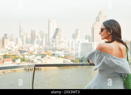Bangkok, Thailand - 11. februar, 2024: kaukasierin Touristen Genießen Sie Shopping Mall Blick aus berühmten Aussichtspunkt über den Fluss an sonnigen heißen Tagen im Südosten Stockfoto