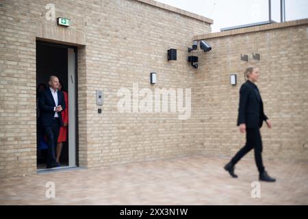 Potsdam, Deutschland. August 2024. Bundeskanzler Olaf Scholz (SPD) geht bei einem Besuch des Potsdamer Synagogenzentrums im Rahmen einer Sommerreise in seinen Wahlkreis hinter einem Leibwächter auf dem Dach. Quelle: Sebastian Christoph Gollnow/dpa/Alamy Live News Stockfoto