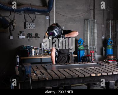 Ein Schweißer bei der Arbeit in einer Werkstatt in Newcastle upon Tyne in England, Großbritannien. Stockfoto