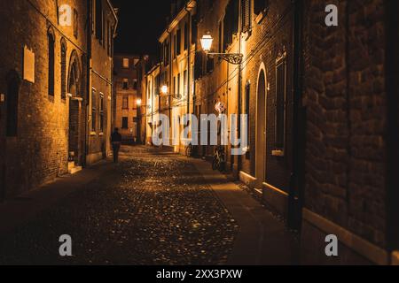 Ein erwachsener Mann spaziert nachts allein in einer einsamen Gasse einer alten Stadt Stockfoto