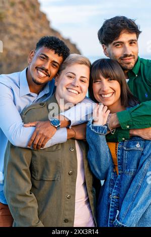 Porträt einer vielfältigen Gruppe glücklicher Freunde, die sich im Freien tummeln. Das Bild fängt Inklusivität, multikulturelle Freundschaft und freudiges miteinander in einem na ein Stockfoto